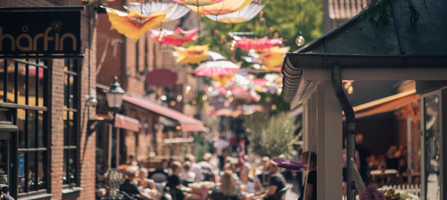 Passage med paraplyer og caféliv